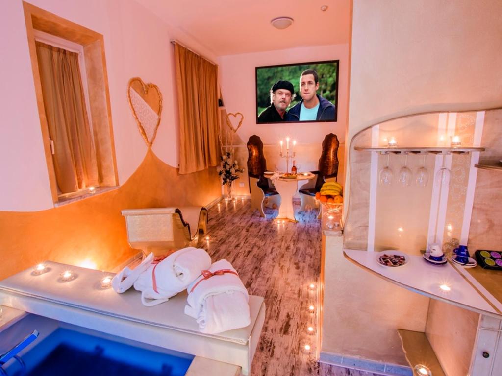 a living room with a bath tub with a picture of a man at Hotel Butterfly in Torre del Lago Puccini