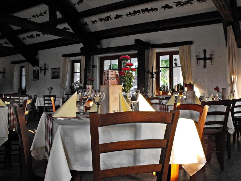 a dining room with tables and chairs and crosses on the wall at Kassai Fogadó in Kaposmérő