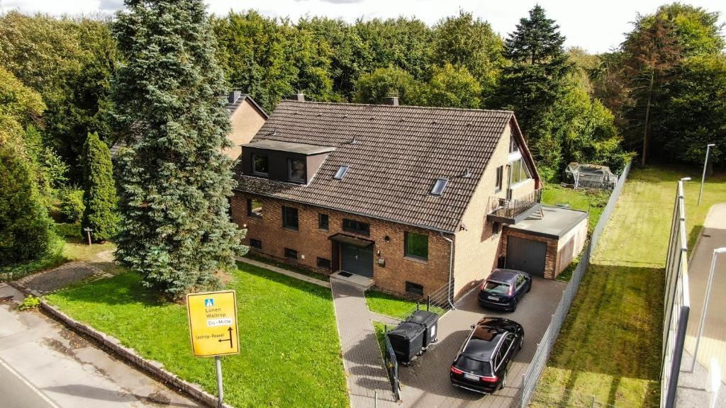 una vista aerea di una casa con auto parcheggiate nel vialetto di monteurzimmer-dortmund-mengede a Dortmund