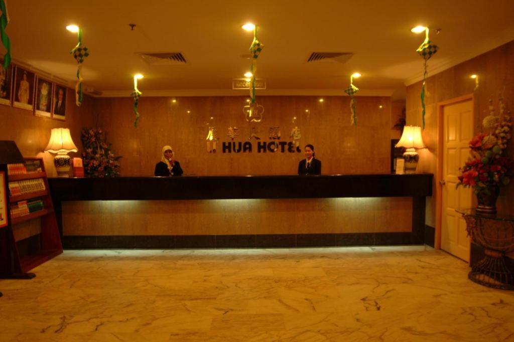 two men standing at the bar in a hotel lobby at Li Hua Hotel Bintulu in Bintulu