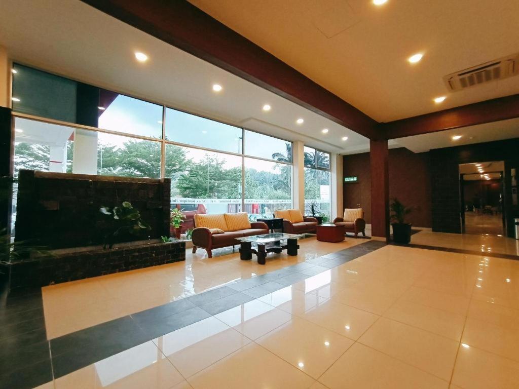 a large lobby with couches and tables and windows at Salak Boutique Hotel in Kampong Jijan Hilir