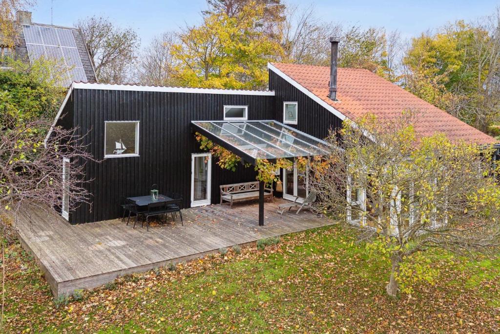 una casa nera con un terrazzo e un solarium di Cozy Holiday Home In Tisvildeleje a Tisvildeleje