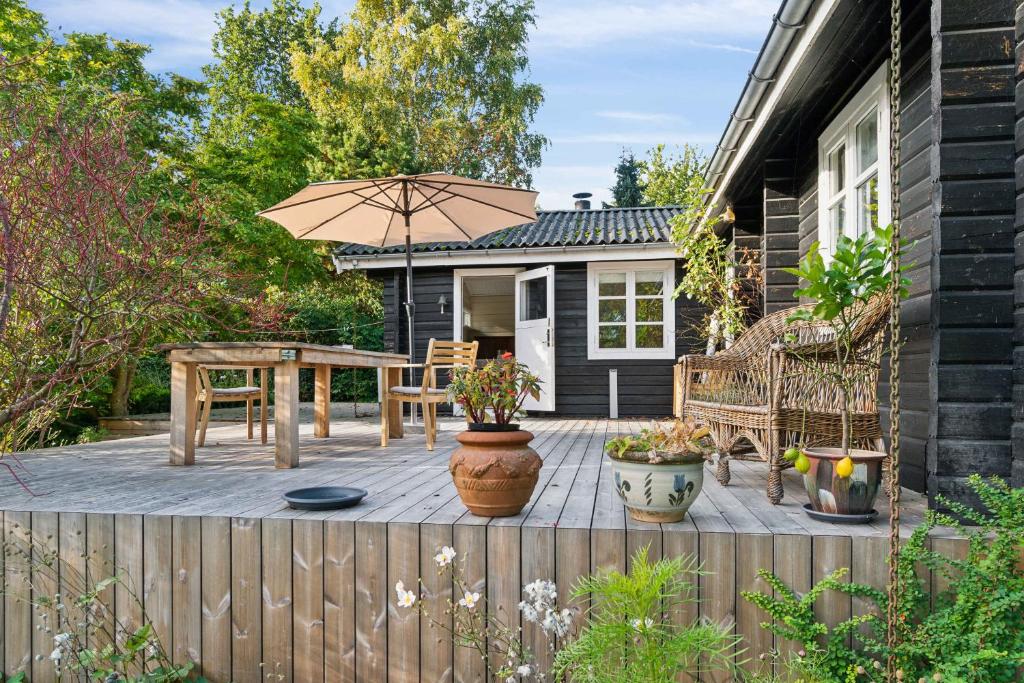 a patio with a table and an umbrella at Lovely Summer House In North Zealand in Vejby