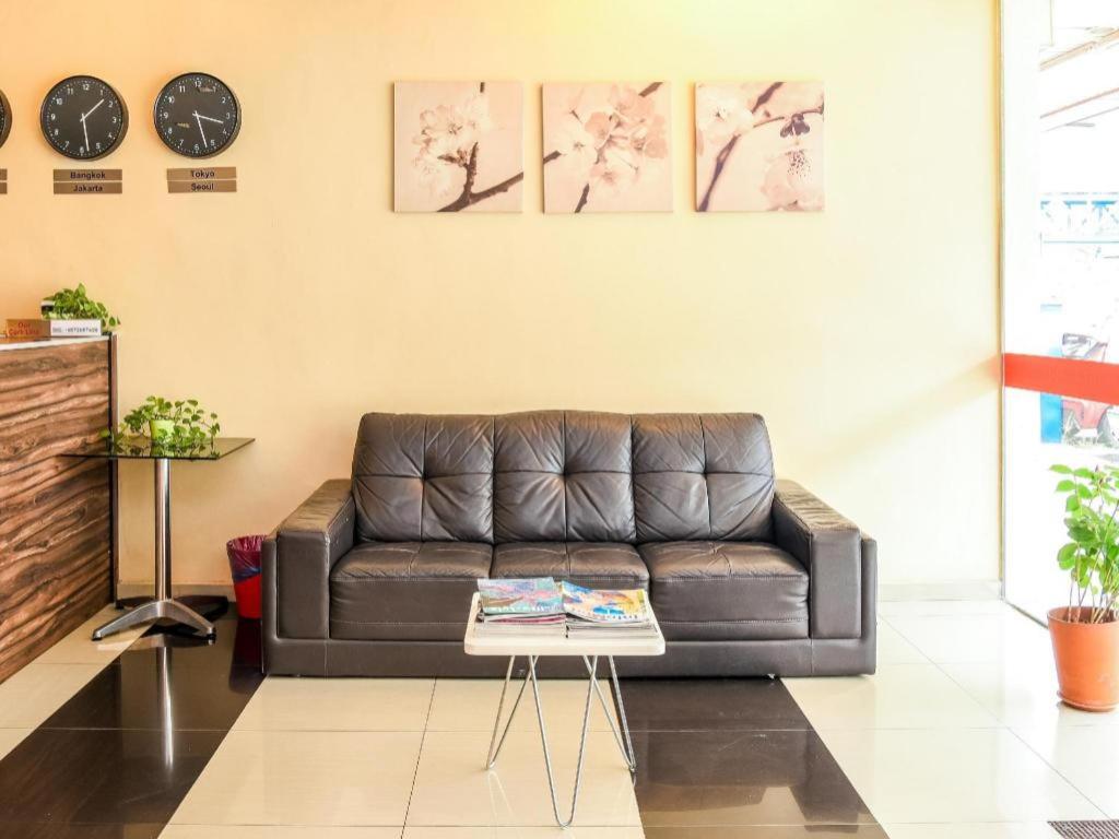 a living room with a brown leather couch at Parc Hotel Pelangi Damansara in Kuala Lumpur