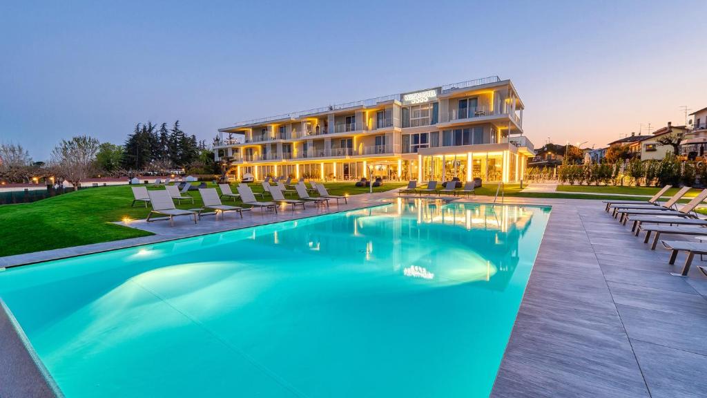 a hotel with a swimming pool in front of a building at Vision Hotel in Peschiera del Garda