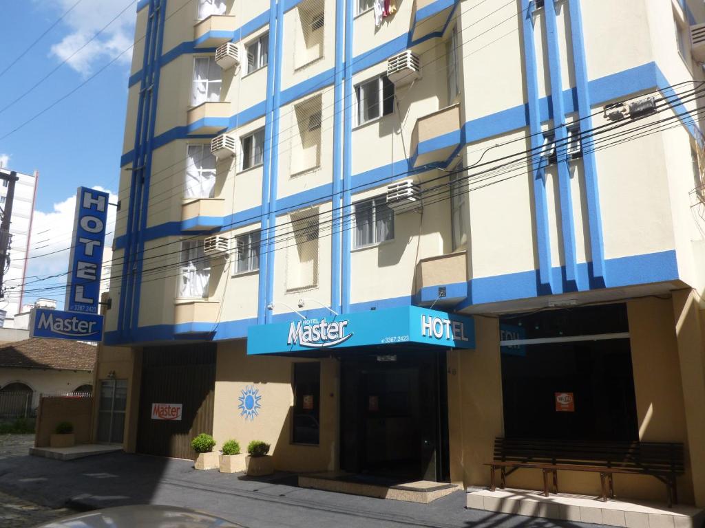 um hotel com um edifício azul e branco em Master Hotel em Balneário Camboriú