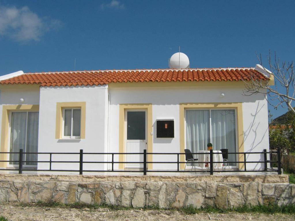 een wit huis met een hek ervoor bij Pangeras Apartments in Pissouri