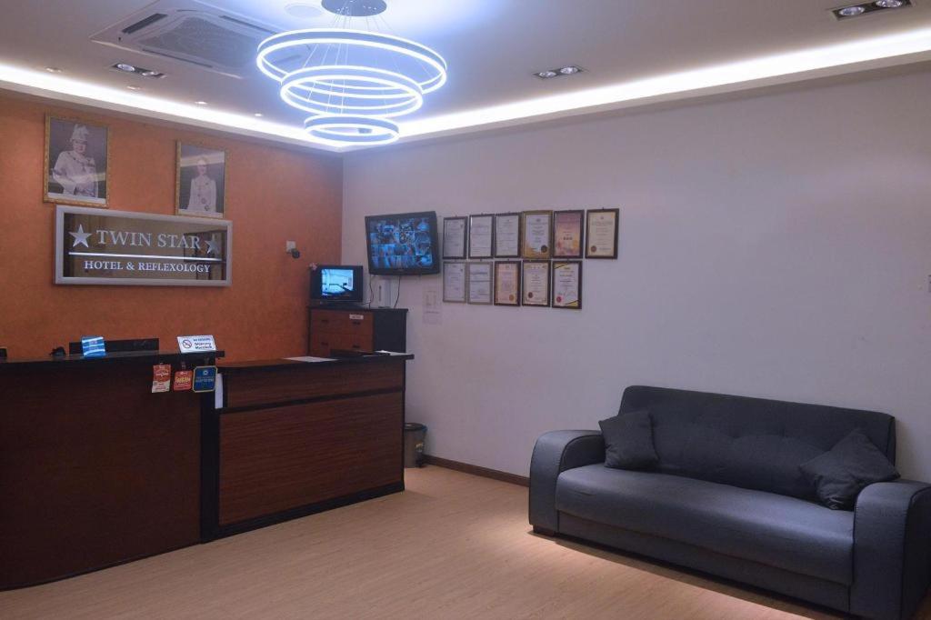 ein Wartezimmer mit einer Couch und einer Kasse in der Unterkunft Twin Star Hotel in Kampong Keteyong