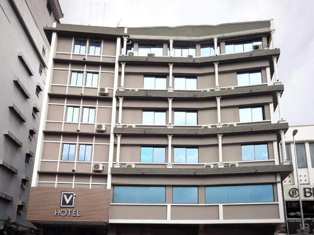 un edificio con un'insegna di un hotel di fronte di V Plus Hotel Ipoh a Ipoh