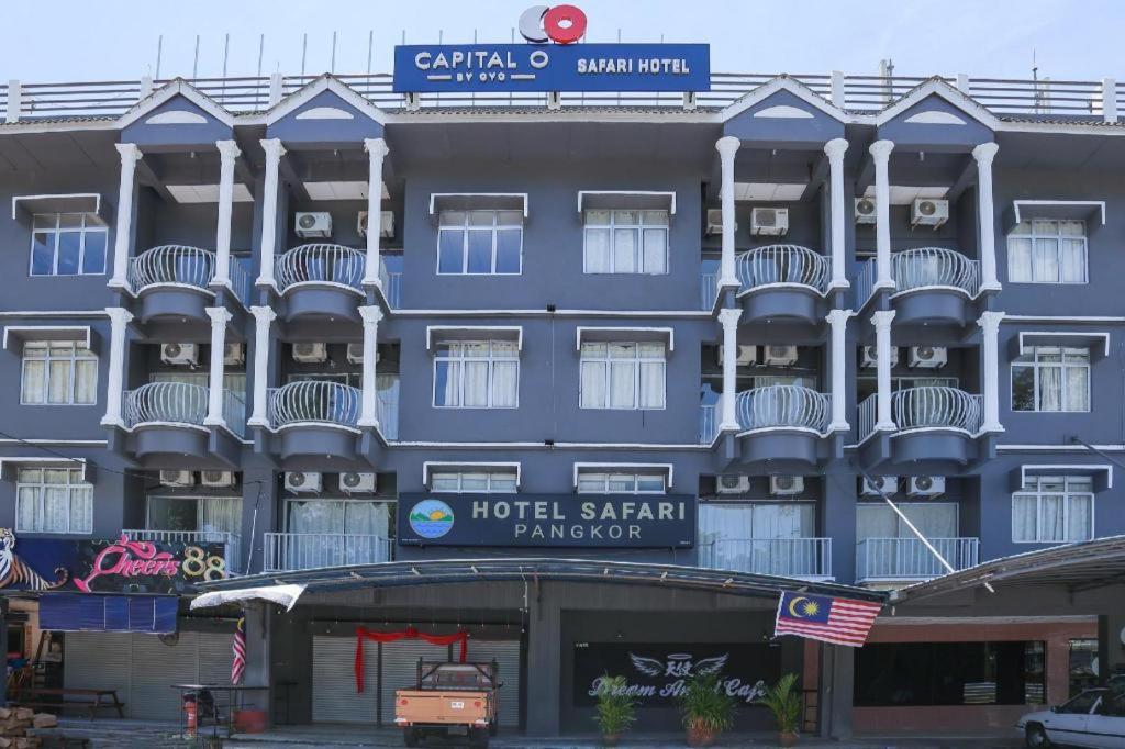 a blue hotel with a sign on top of it at Capital O 89876 Safari Hotel in Pasir Bogak