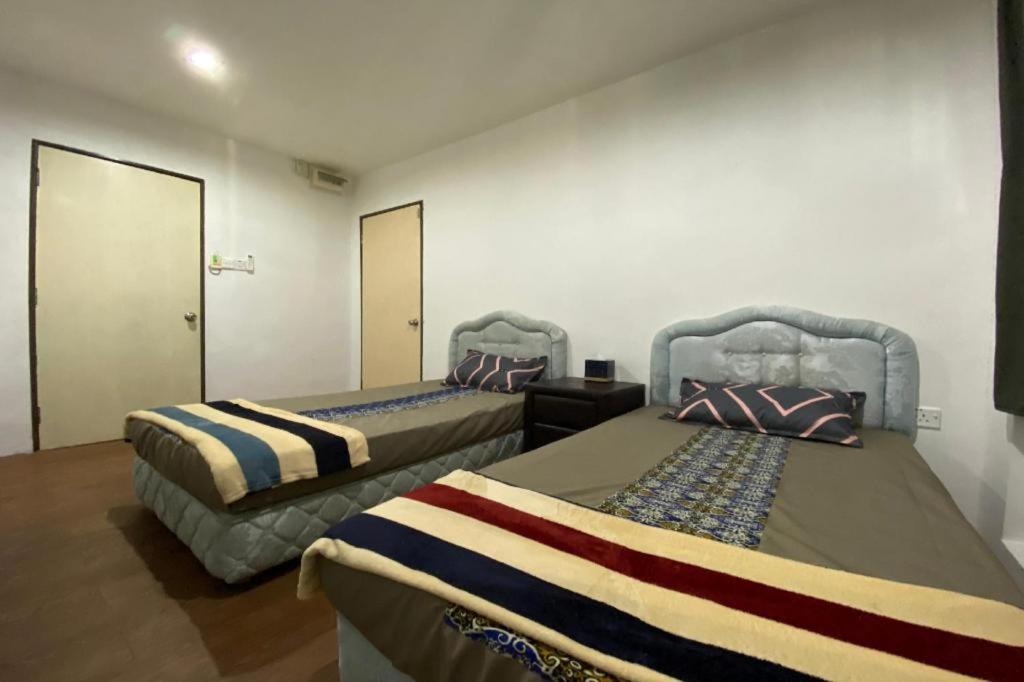 two beds in a room with two at OYO 90397 Rimba Lodge in Kampong Nasob