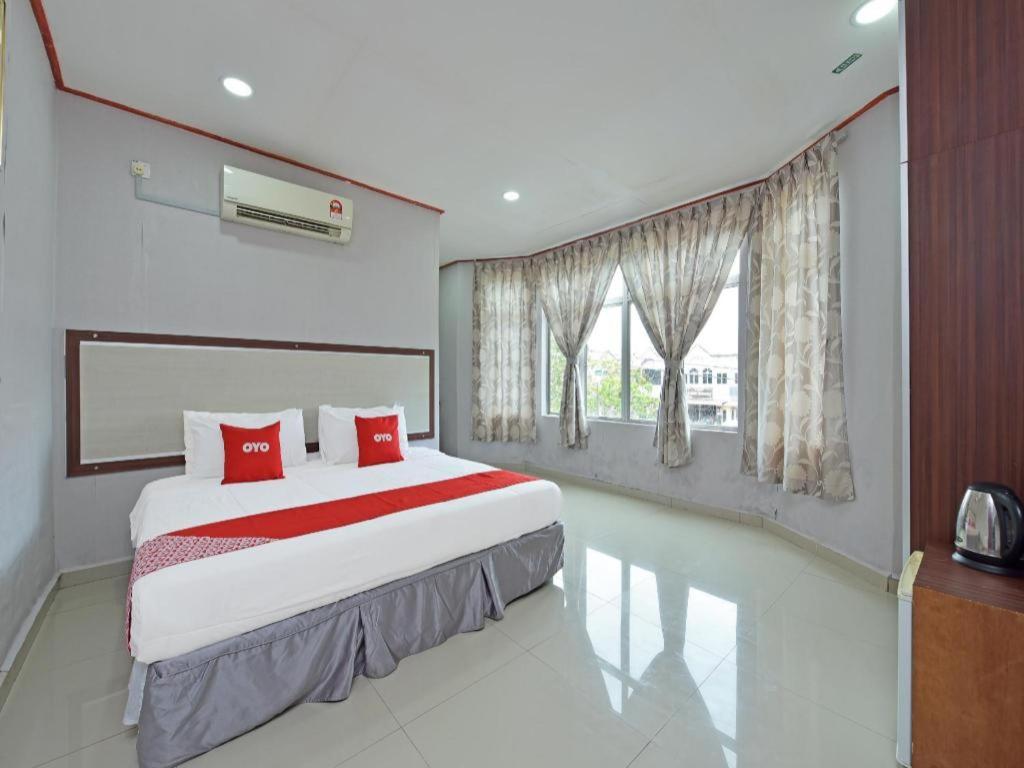 a bedroom with a large bed with red pillows at SUPER OYO 818 Hotel 11 in Bandar  Pusat Jengka