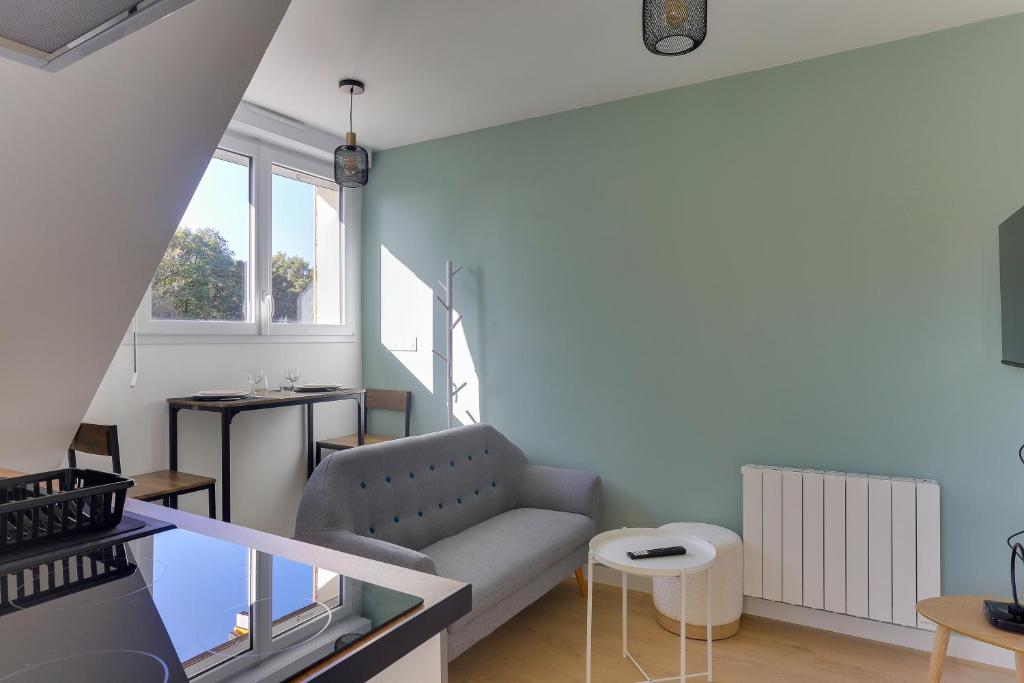 un salon avec un canapé et une table dans l'établissement Viviane - appt avec jardin partagé, à Bruz