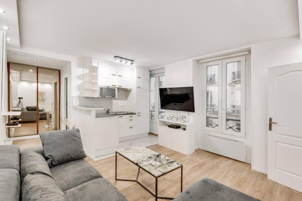 un salon blanc avec un canapé et une table dans l'établissement Appart 4pers#Malesherbes#Parc Monceau, à Paris