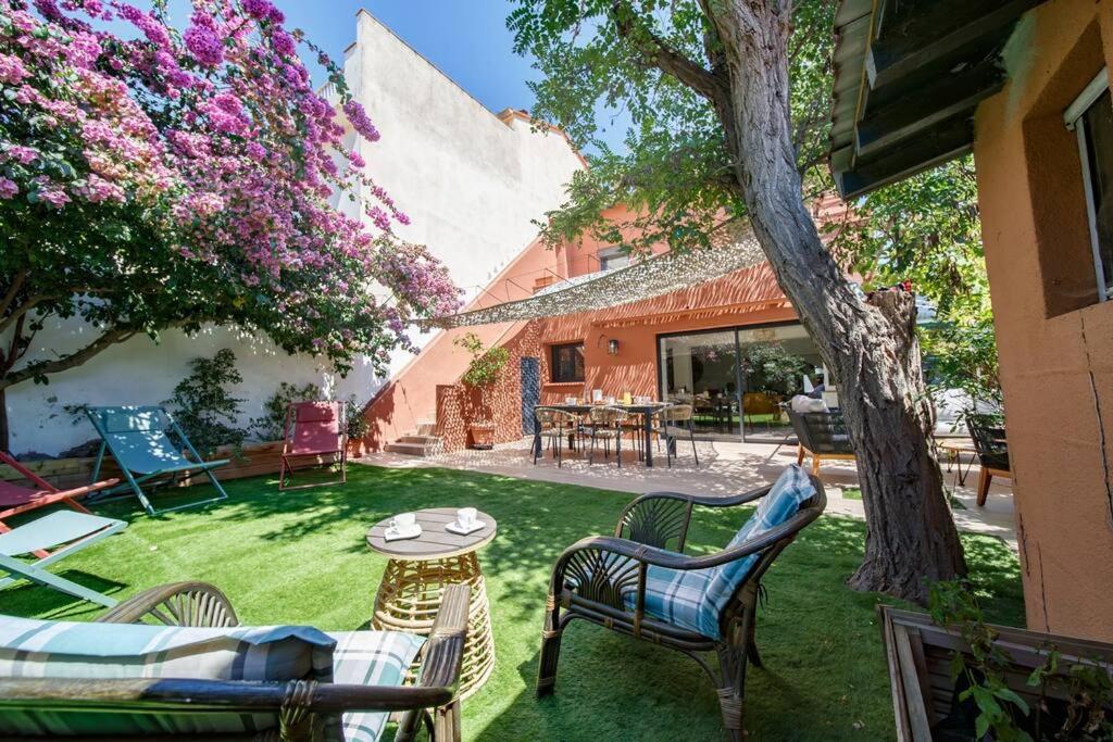 une cour avec des chaises, une table et un arbre dans l'établissement La maison du soleil à 2 pas de la plage, à Canet