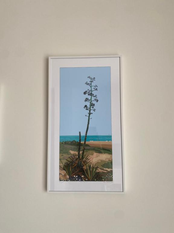a framed picture of a tree on a wall at Apartahotel Vistamar San José in San José