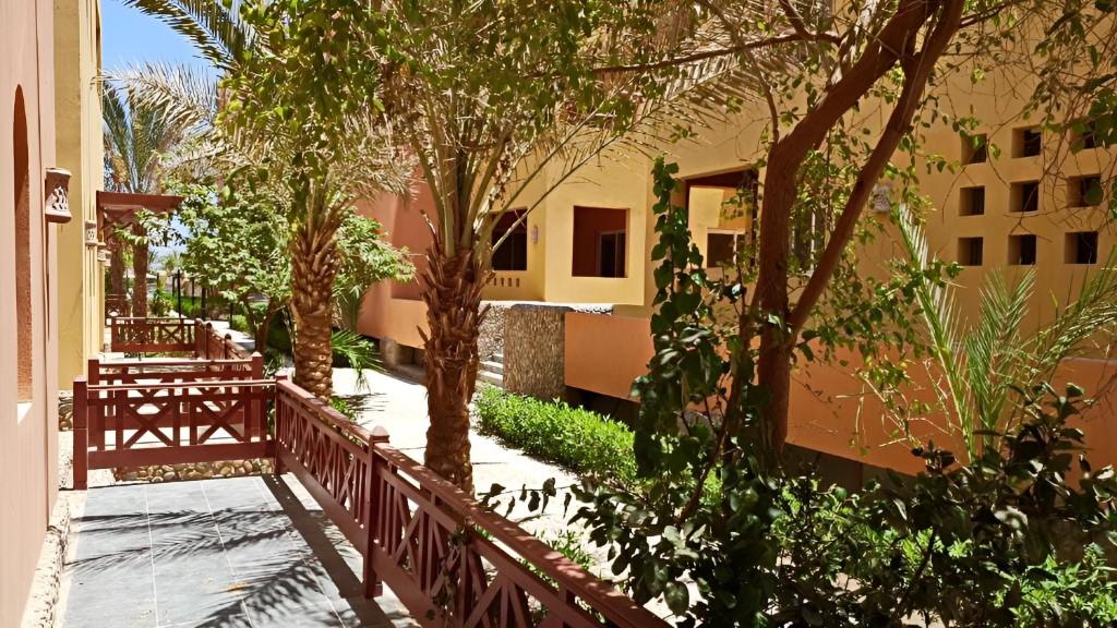 a courtyard with trees and a fence and a building at Al-Dora Resort Hurghada in Hurghada