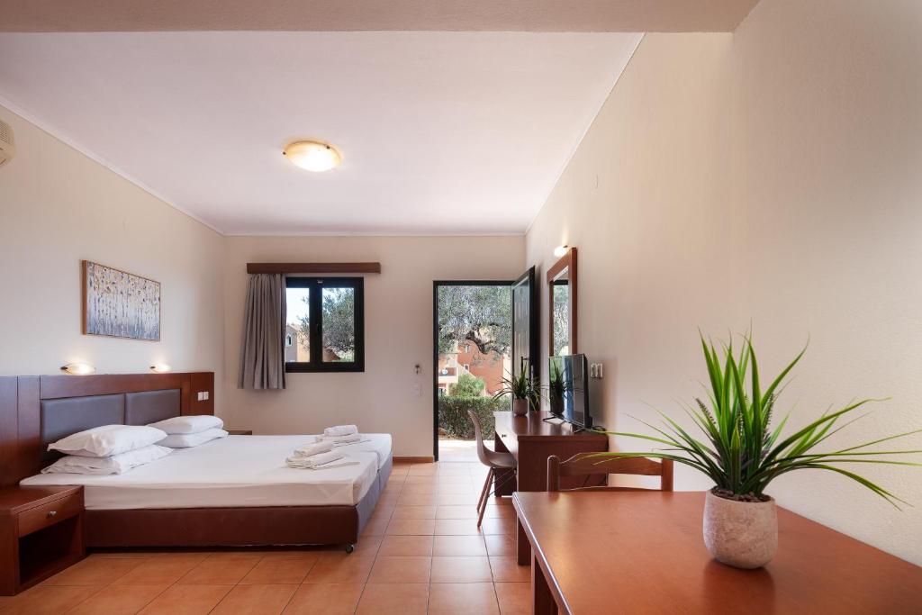 a hotel room with a bed and a table at Dia Apartments in Hersonissos