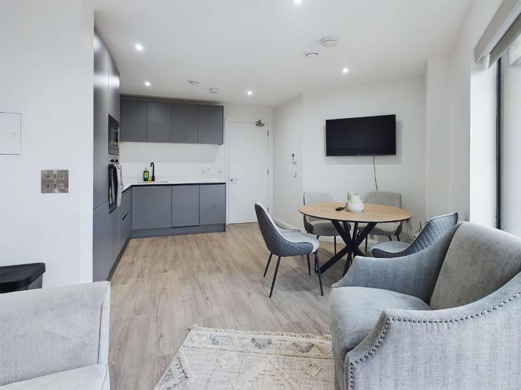 eine Küche und ein Wohnzimmer mit Tisch und Stühlen in der Unterkunft Modern 2 bedroom Apartment in Belfast in Belfast
