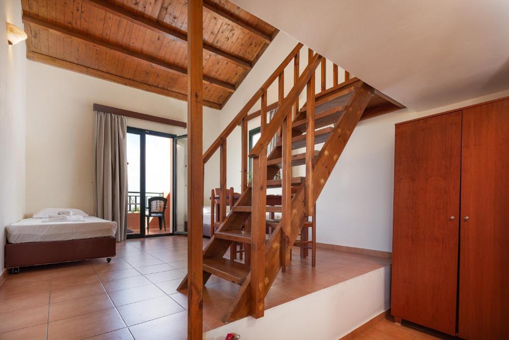 a wooden staircase in a room with a bedroom at Dia Apartments in Hersonissos
