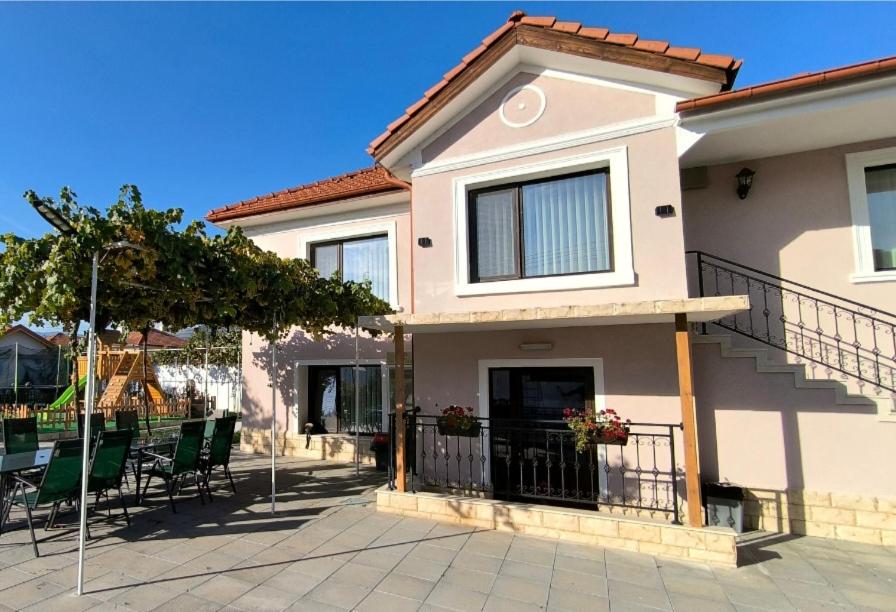 a house with chairs and a table in front of it at Къща за гости Етерна - Guest house Eterna in Starosel