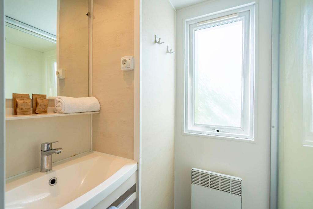a bathroom with a sink and a window at Camping Paradis 4 étoiles A La Corniche La Rochelle Angoulins in Angoulins-sur-Mer