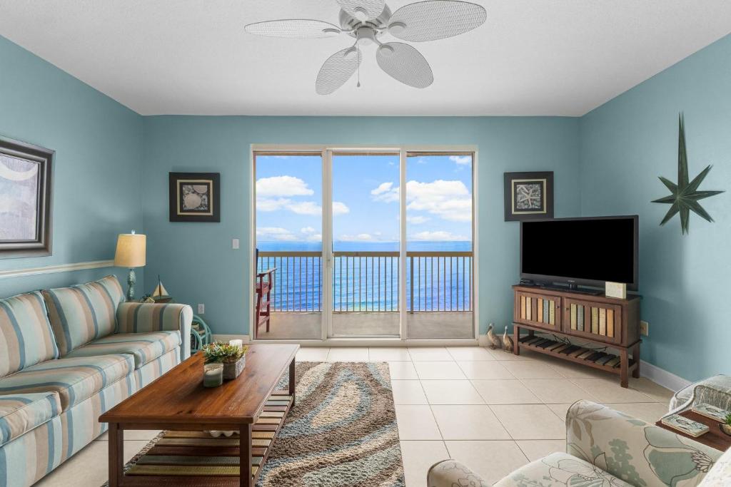 un soggiorno con un divano e una televisione di Celadon #2106 a Panama City Beach