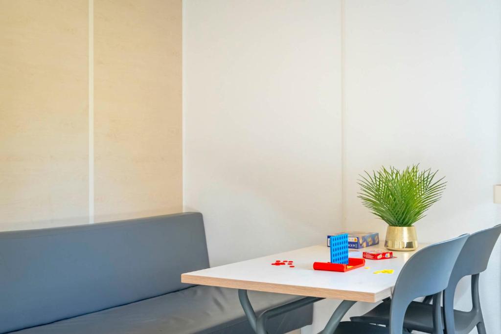 a table and chairs in a room with a plant at Camping Paradis 4 étoiles A La Corniche La Rochelle Angoulins in Angoulins-sur-Mer