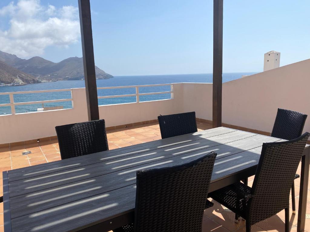 a table and chairs on a balcony with a view of the ocean at Apartahotel Vistamar San José in San José
