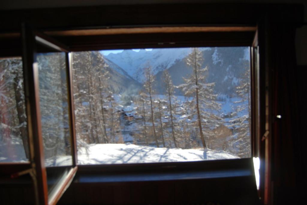 une fenêtre avec vue sur une montagne enneigée dans l'établissement B&B della Miniera, à Cogne