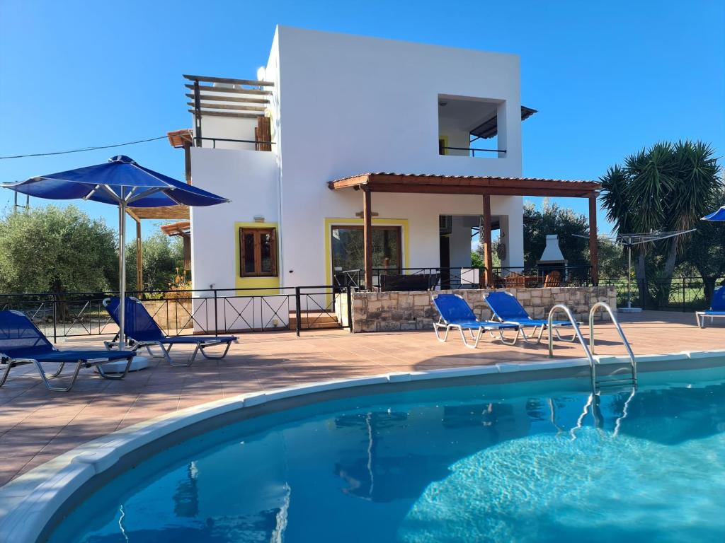 a villa with a swimming pool in front of a house at Villa Helios, private gated pool + big patio in Almirida