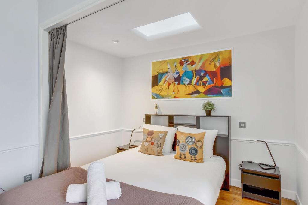 une chambre avec deux lits et un tableau au mur dans l'établissement Appartement Cosy - 59 Rue Froidevaux Paris Montparnasse, à Paris