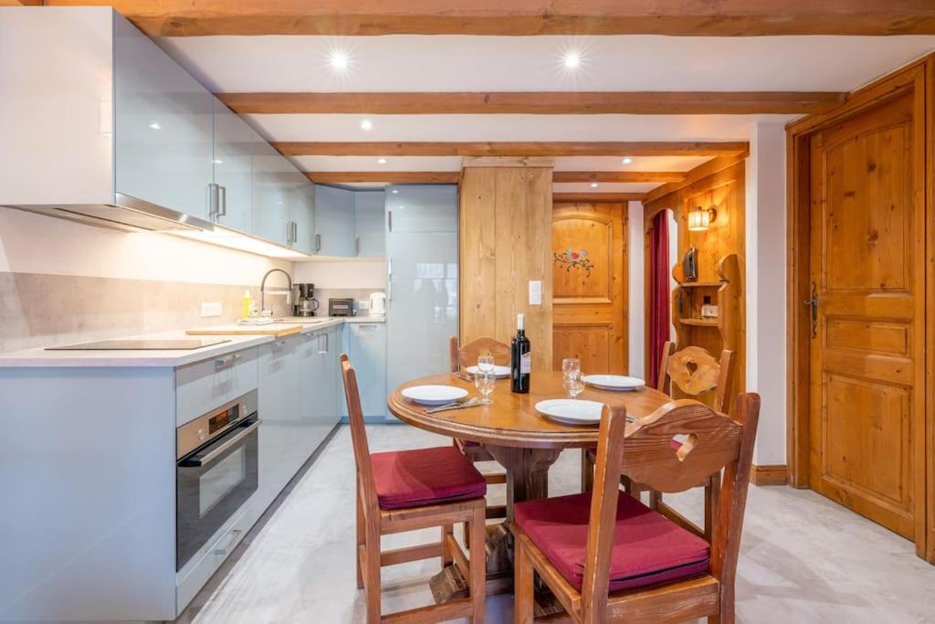 - une cuisine avec une table et des chaises en bois dans l'établissement Le Cristal - Central apartment close to the slopes & Free Parking - By Cozee Rentals, à Chamonix-Mont-Blanc