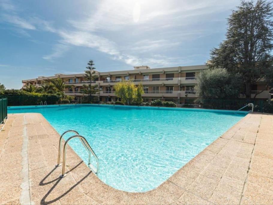a large swimming pool in front of a building at Appartement lumineux Vue Mer, Piscine et tennis in Nice