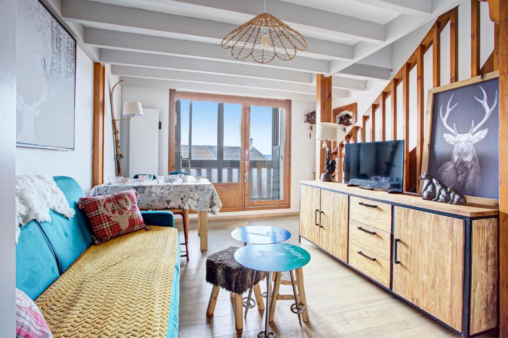 a living room with a blue couch and a tv at Les Alysses - Maison pour 5 avec garage in Font-Romeu