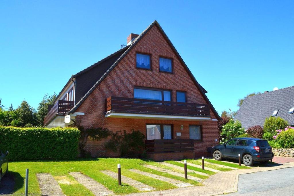 a house with a car parked in front of it at Wiesenweg - Wohnung 06 in Wyk auf Föhr