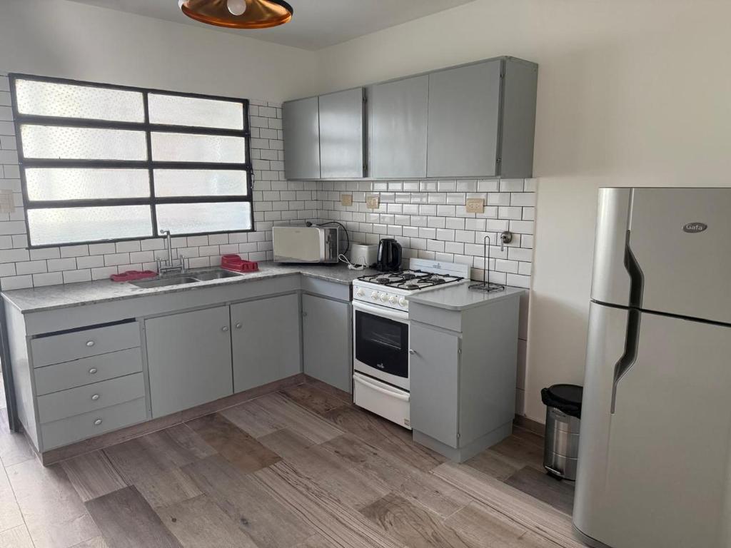 a kitchen with white cabinets and a stove and a refrigerator at Aloha II in Rosario