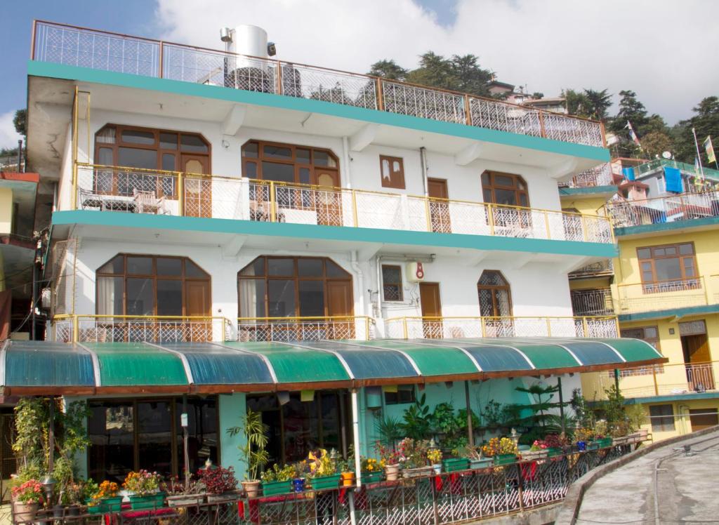 ein Gebäude mit Balkonen und Blumen davor in der Unterkunft Green Hotel in Dharamshala