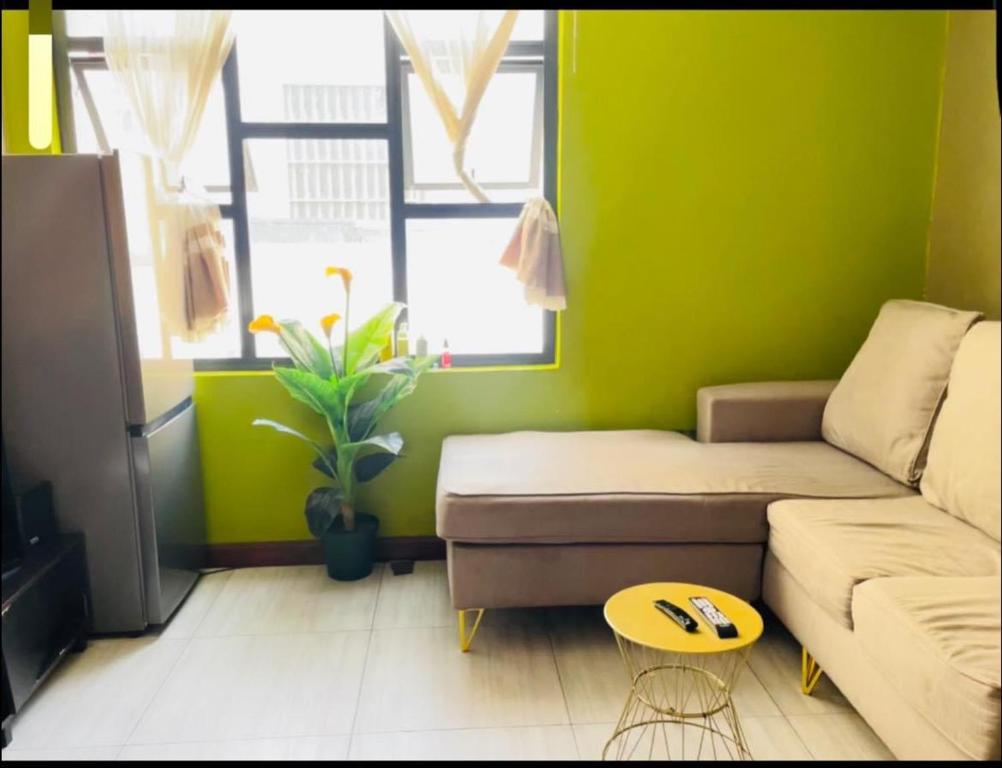 a green living room with a couch and a table at Feel at home in Durban