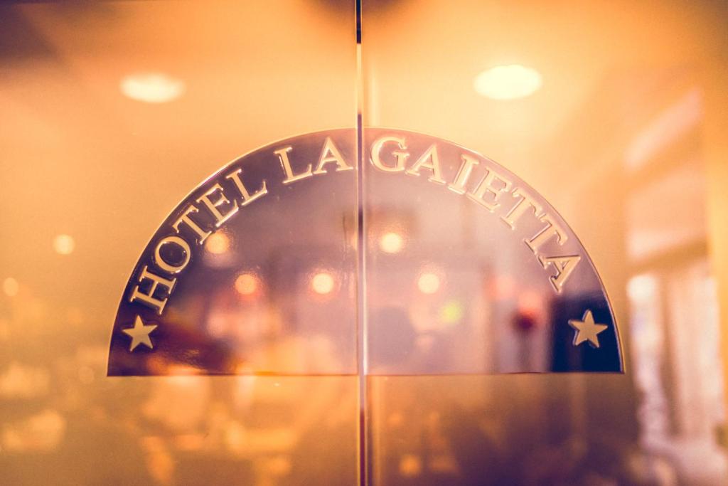 een glazen deur met het bord voor a la galeria bij Hotel La Gaietta in Millesimo