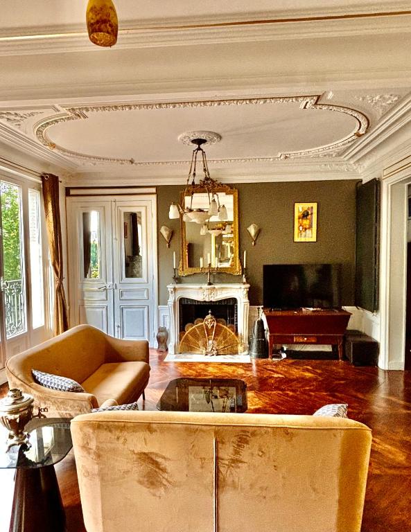 un salon avec un canapé et une cheminée dans l'établissement Charme, confort et tradition à côté de Montmartre, à Paris