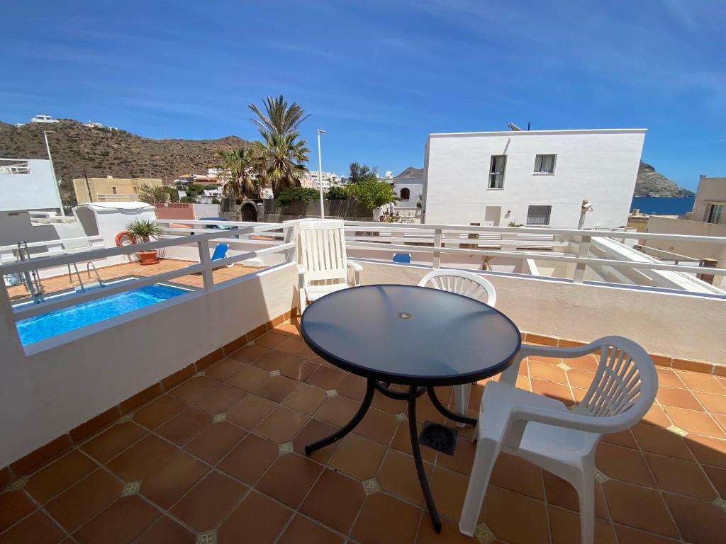 a patio with a table and two chairs on a roof at Apartahotel Vistamar San José in San José