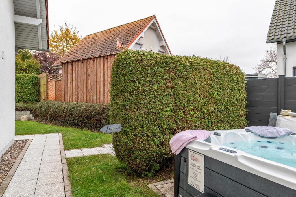 a bath tub in a yard next to a bush at Domizil Eden - Erdgeschoss in Göhren-Lebbin
