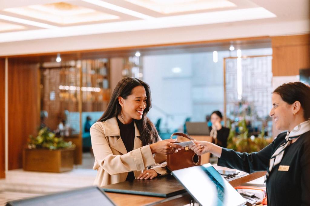 two women shaking hands at a table in an office at Electra Metropolis in Athens