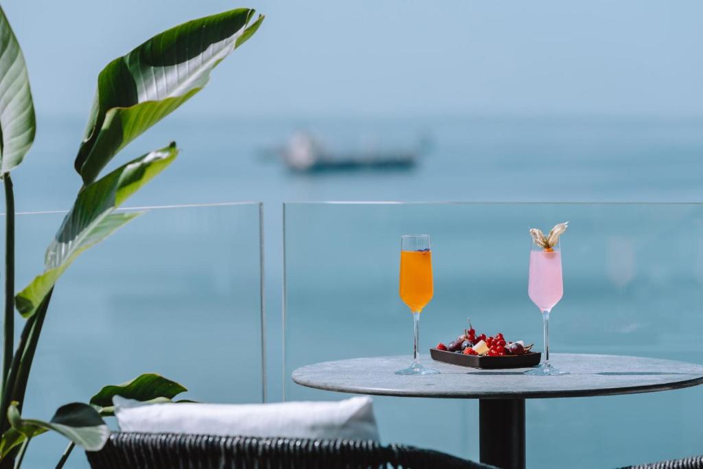 a table with a bowl of fruit and two drinks at Electra Palace Thessaloniki in Thessaloniki