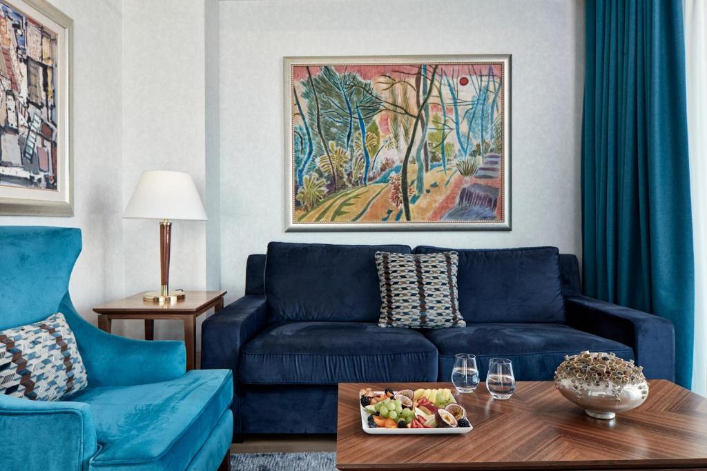 a living room with a blue couch and a table at Electra Metropolis in Athens
