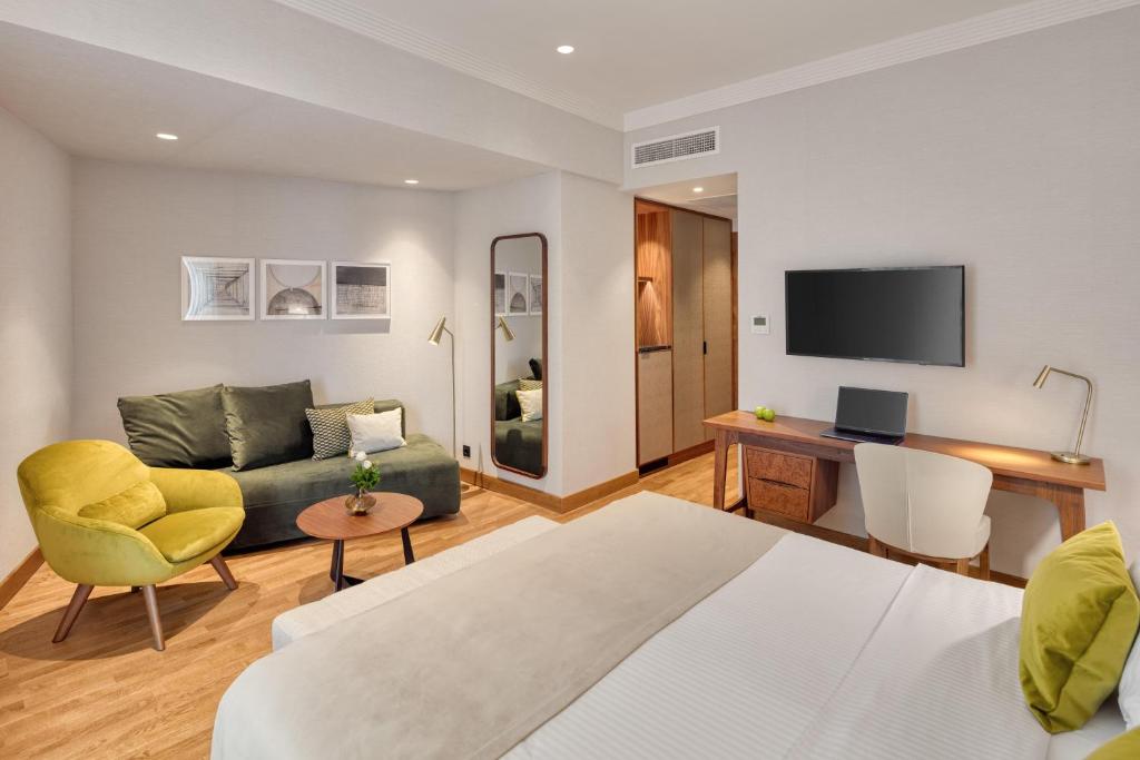 a living room with a couch and a desk at Electra Palace Thessaloniki in Thessaloniki