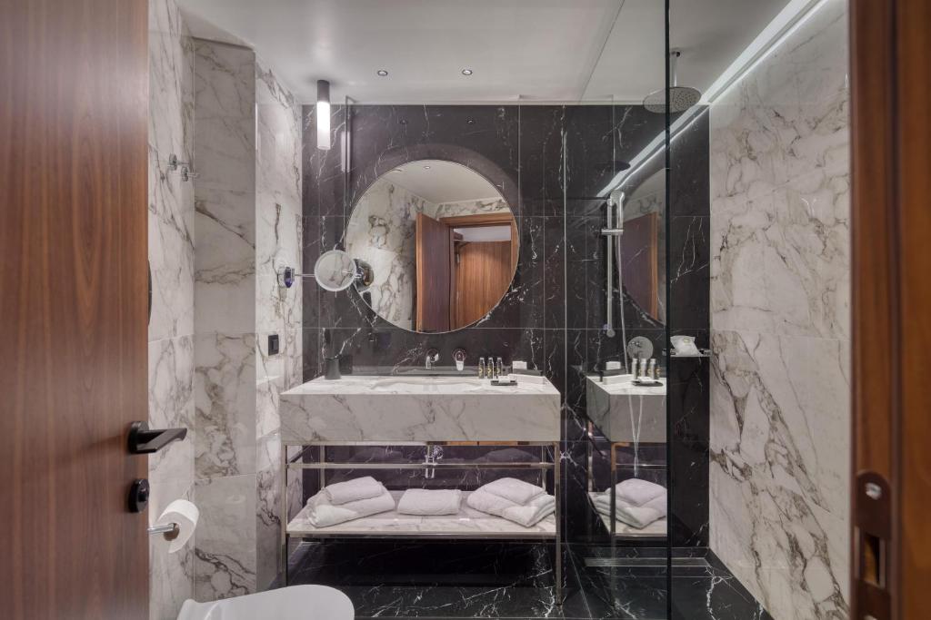 a bathroom with a sink and a mirror at Electra Palace Thessaloniki in Thessaloniki