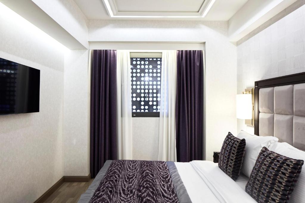a hotel room with a bed and a window at Electra Metropolis in Athens