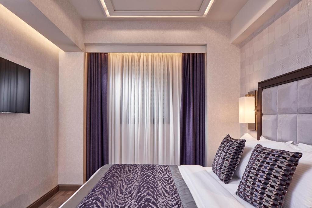 a hotel room with a bed and a window at Electra Metropolis in Athens
